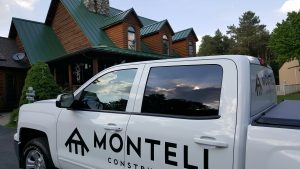 A Montell Construction truck in front of a home with a metal roof installed