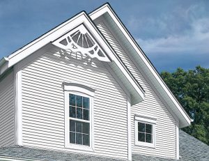The upper level of a home with bright white siding and detailed trimwork