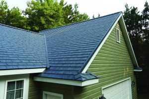 View of an asphalt shingle roof over a home with green siding