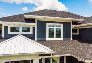 Home with blue siding and grey asphalt roofing shingles